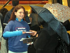 Molly Willson, of Valley City, N.D., hands paper to a passerby in Times Square.