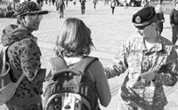 Army Staff Sargeant Apryl Watroba hands out fliers to BYU students are part of a recruiting effort at Brigham Square. She previously was stationed in Iraq and is now an Army recruiter in Provo.