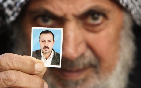  The father of senior Hamas military commander Mahmoud al-Mabhouh with a photo of his son