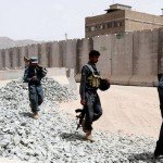 Afghan policemen secure a police compound that came under attack in Kandahar