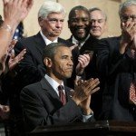 President Barack Obama, center, applauds after signing the Dodd Frank-Wall Street Reform and Consumer Protection Act in a ceremony