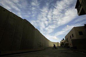 A Palestinian boy rides his bicycle next to a section of Israel’s barrier. AP / Emilio Morenatti