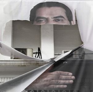 What's left of the face of ex-president Zine el- Abidine Ben Ali stares out from a torn poster in Tunis Jan. 16