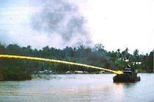 Vietnam-River boat firing napalm to kill and rout the enemy