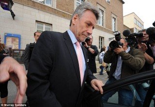 Neil Wallis leaving police station