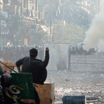 tahrir battle -Protesters throw stones at police who are firing tear gas, during clashes near Tahrir Square in Cairo November 23, 2011.