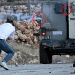 Mustafa Tamimi (left) a moment before his injury. Circled in red are the barrel of the gun and the projectile that hit him
