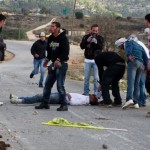 Nabi Saleh- A group of Palestinian men surround Mustafa Tamimi after he was shot