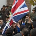 Protesters bring down the flag of the British Embassy in Tehran
