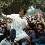 Students lift cricket star turned politician Imran Khan after his arrival at the University of Punjab in Lahore