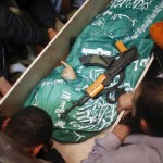 Gazans mourn next to the body of Hamas militant Mohammed al Hams during his funeral in Gaza City November 15, 2012.