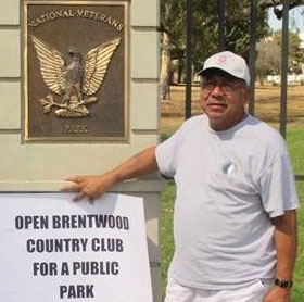 Howard Hernandez, past State Commander of the American G.I. Forum and a Vietnam War Veteran, holds a sign directing that a public park be built at the Brentwood Country Club instead of on Veterans’ land, which is illegal.