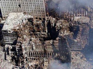 An aerial view on September 17th, 2001 shows only a small portion of the scene where the World Trade Center collapsed following the supposed Sept. 11 terrorist attack. Surrounding buildings were obviously heavily damaged by the scattered debris and massive force of the imploding twin towers ~ before DOJ head and future Director of Homeland Security, Michael Chertoff retained and destroyed all the evidence from this clearly evident, but never declared crime scene. (U.S. Navy photo by Chief Photographer's Mate Eric J. Tilford)