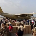 Workers and Southern Resistance fighters unload aid shipment from a Saudi military cargo plane at the international airport of Yemen’s southern port city of Aden