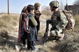 Afghan children talk with a soldier