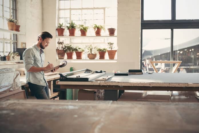 Design business owner checking stock on a clipboard